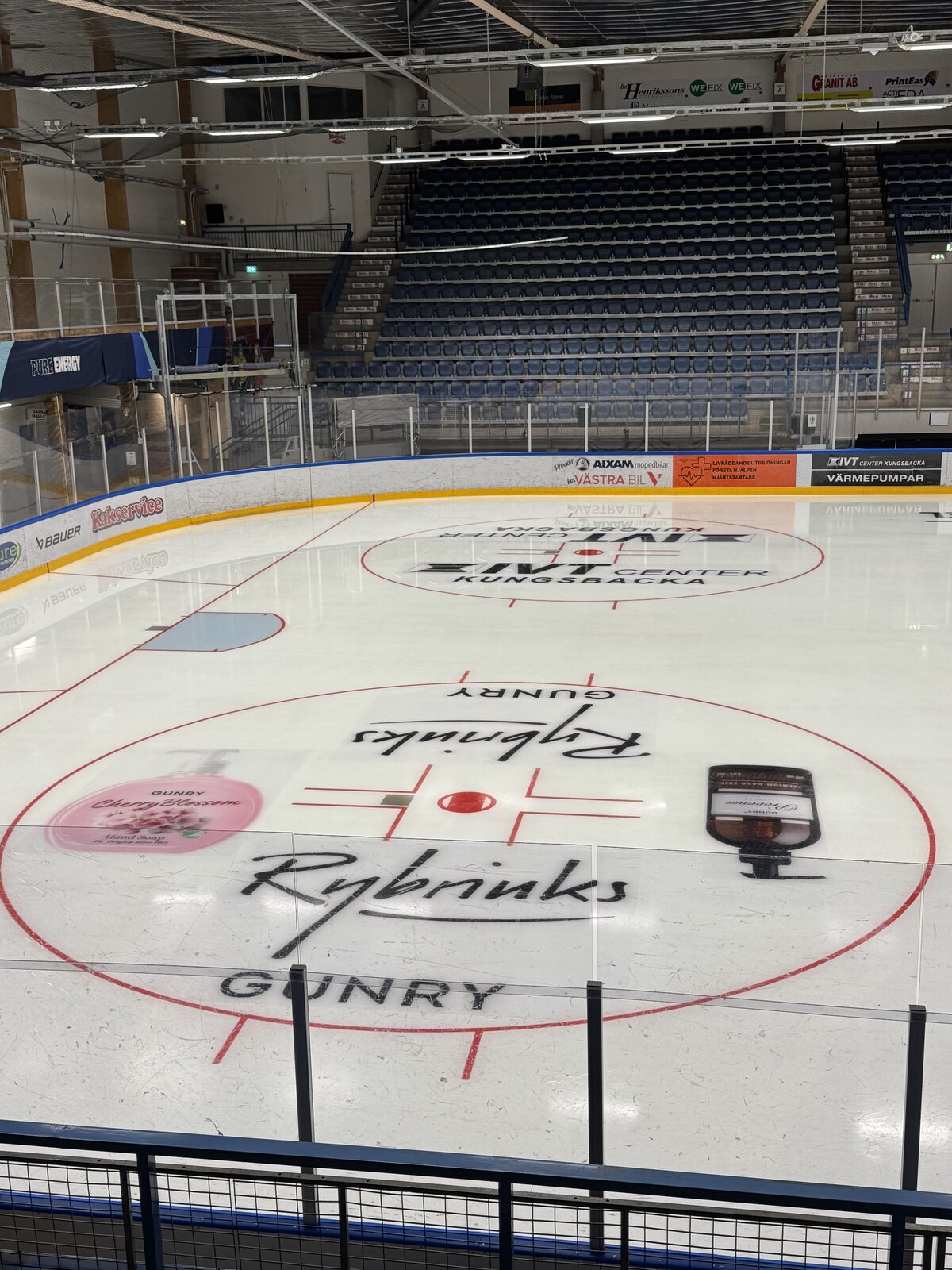 Ishockeyrink sedd från läktaren med reklam i tekningscirklarna