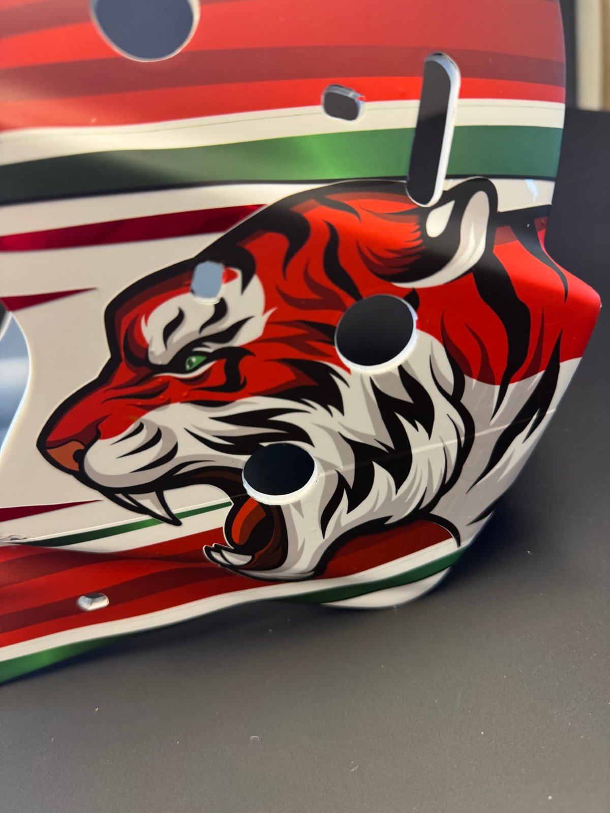 Närbild på en röd tiger på en folierad målvaktsmask